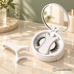 Round white magnetic eyelash storage case with two lashes and an applicator beside it.