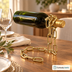 Gold floating chain wine bottle holder displaying a wine bottle on a styled dining table.