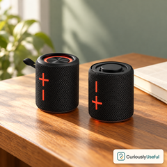 Two sections of the black magnetic Bluetooth speaker standing apart on timber with a clearly visible Curiously Useful logo.